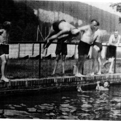 schwarz-weiß Fotografie des Freibades, Männer springen vom Beckenrand